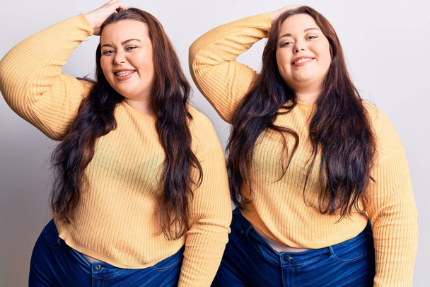 Young plus size twins wearing casual clothes smiling confident touching hair with hand up gesture, posing attractive and fashionable  - Foto, imagen