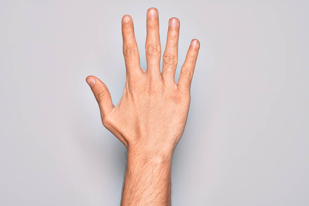 Рука білошкірого чоловіка, що показує пальці над ізольованим білим тлом, підрахунок числа 5 показує п'ять пальців
 - Фото, зображення
