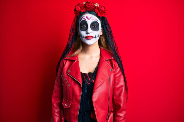 Žena, která měla na sobě den mrtvého kostýmu přes červenou, se uvolnila s vážným výrazem ve tváři. jednoduchý a přirozený pohled do kamery.  - Fotografie, Obrázek