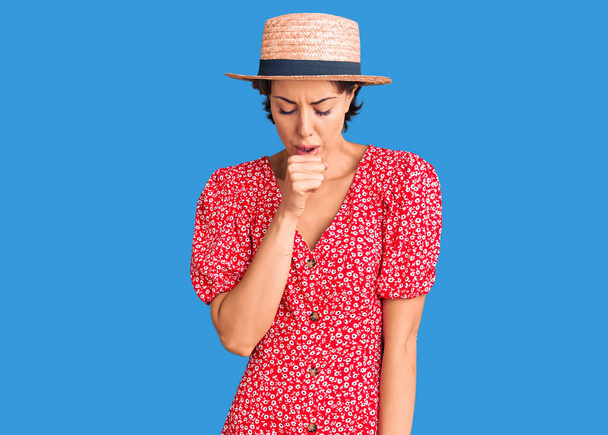 Yaz şapkası takan genç ve güzel bir kadın kendini iyi hissetmiyor ve soğuk algınlığı veya bronşitin belirtisi olarak öksürüyor. sağlık hizmeti kavramı.  - Fotoğraf, Görsel