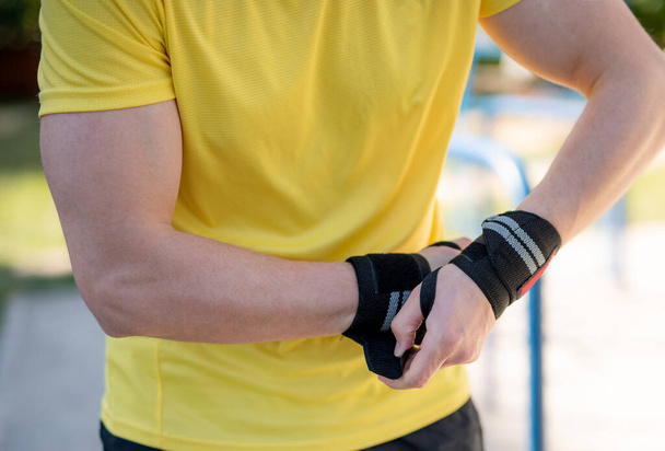 Elastic wrist bandage on male hands - Foto, imagen