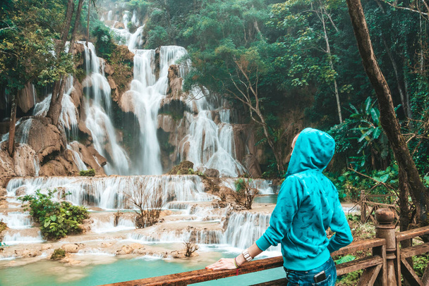 ragazza turistica godere di Kuang Si cascata, Luang Prabang, Laos. Giovane donna divertirsi e felice visite turistiche con la natura a Tat Kuang Si cade. - Foto, immagini