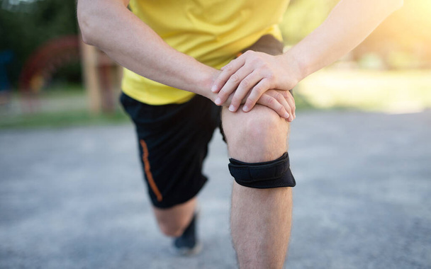 Man exercising with protective knee bandage - Foto, Imagen