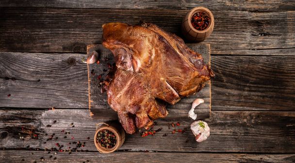 Costillas picantes de cerdo ahumadas calientes. Carne de barbacoa en una antigua tabla de cortar de madera vintage. - Foto, Imagen