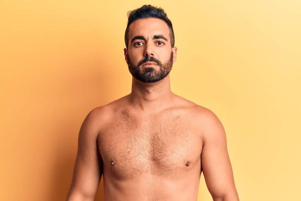 Junger hispanischer Mann ohne Hemd mit ernstem Gesichtsausdruck. einfacher und natürlicher Blick auf die Kamera.  - Foto, Bild