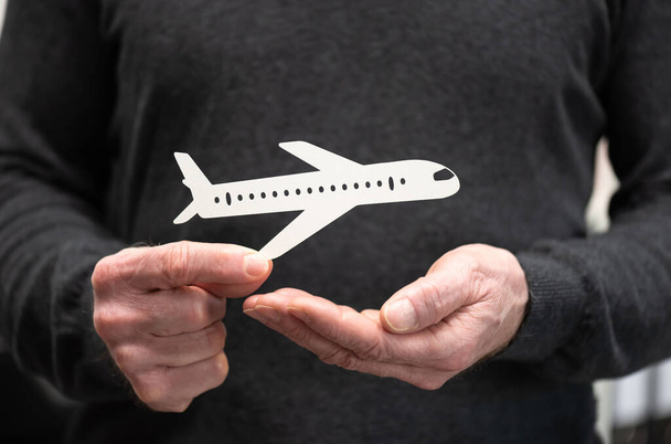 Άντρας που κατέχει χάρτινο αεροπλάνο · έννοια της ασφάλισης πτήσης - Φωτογραφία, εικόνα