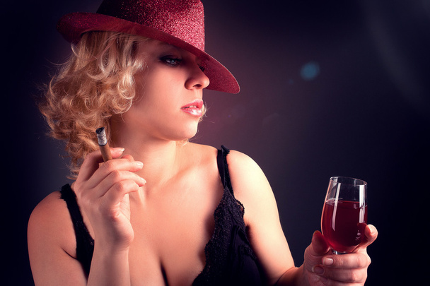 Woman in hat with wine red in glass with sigar - Fotó, kép