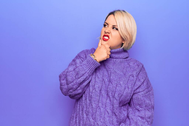 Beautiful blonde plus size woman wearing casual turtleneck sweater over purple background Thinking worried about a question, concerned and nervous with hand on chin - Photo, image