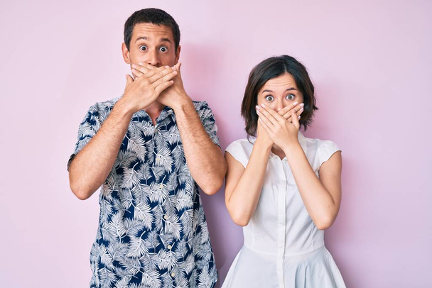 Krásný pár v neformálním oblečení šokované zakrytí úst s rukama za omyl. tajný koncept.  - Fotografie, Obrázek