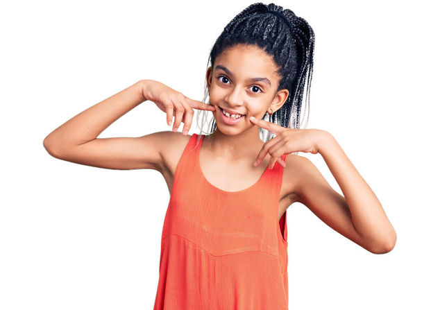 Cute african american girl wearing casual clothes smiling cheerful showing and pointing with fingers teeth and mouth. dental health concept.  - Zdjęcie, obraz