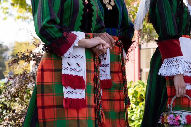 Detalles del traje tradicional de folclore búlgaro en bailarinas jóvenes. Elementos de vestido popular nacional con patrones bordados en las niñas del conjunto Trakia. Disparo en Plovdiv Bulgaria - Foto, imagen