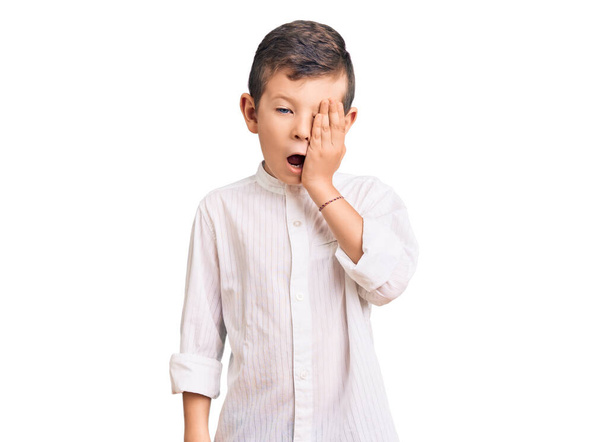 Cute blond kid wearing elegant shirt yawning tired covering half face, eye and mouth with hand. face hurts in pain.  - Photo, Image