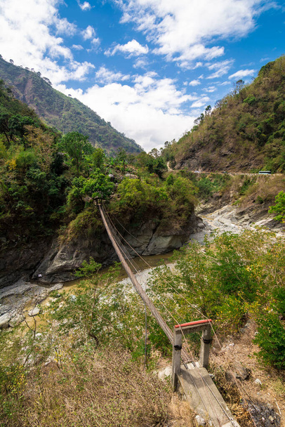 Un petit pont suspendu relie deux points séparés par une rivière le long de la route Kennon dans la province de Benguet, aux Philippines. - Photo, image