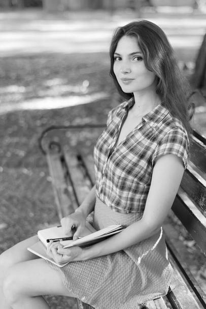 Young girl student on a bench. Black and white photo. BW - Foto, afbeelding
