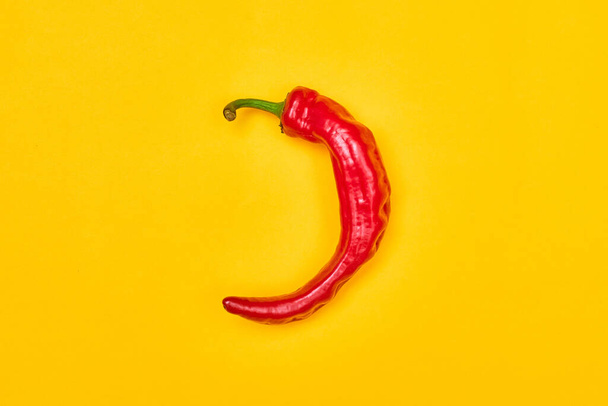red hot pepper on a yellow background top view one - Valokuva, kuva