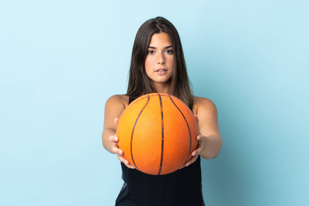 fiatal brazil lány elszigetelt kék háttér játszik kosárlabda - Fotó, kép