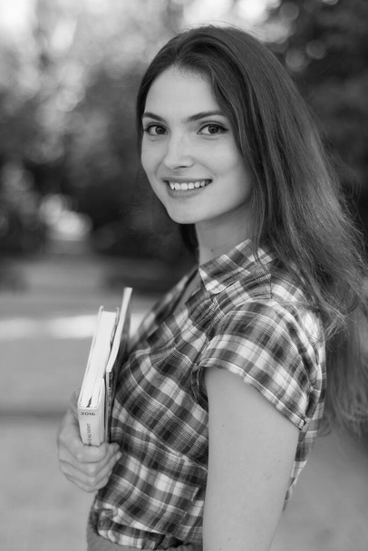 Chica estudiante en falda y camisa a cuadros. Foto en blanco y negro. BW - Foto, imagen