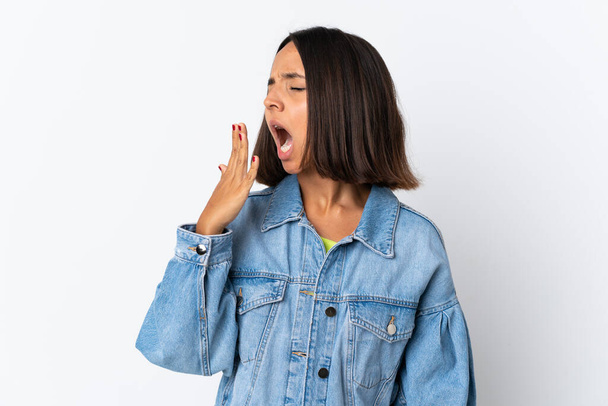 Young latin woman isolated on white background yawning and covering wide open mouth with hand - Foto, immagini