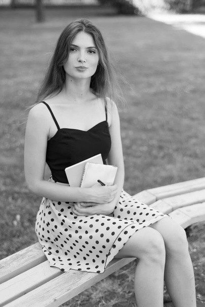 Girl student on a bench. Black and white photo. BW - Φωτογραφία, εικόνα