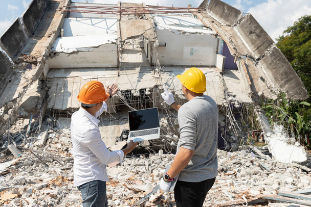 Nadzorca kontroli wyburzeń i wykonawca omawiający wyburzenie budynku. - Zdjęcie, obraz