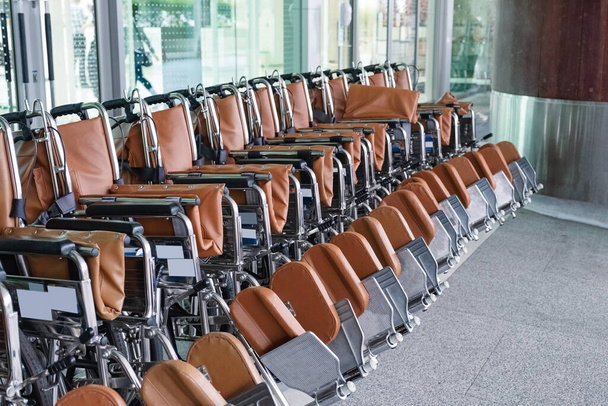 Ряд інвалідних візків, припаркованих для обслуговування пацієнтів у лікарні
 - Фото, зображення