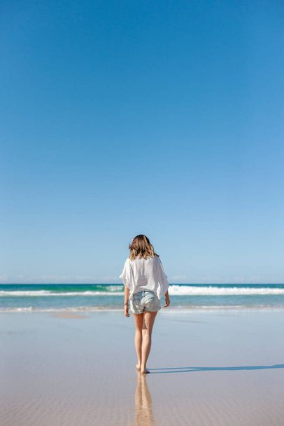 A young woman walking at the tropical paradise beach, Byron Bay, Australia - Фото, зображення