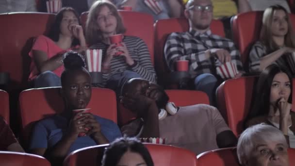 映画の間に眠っている暗い肌の男性の観客 - 映像、動画
