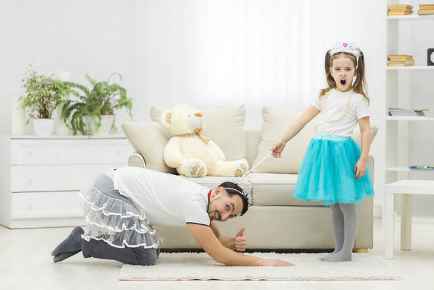 Photo of dad and daughter playing in room. - Foto, afbeelding