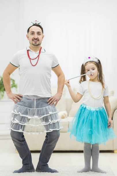 Father and his little daughter dancing against white background. - Foto, Bild
