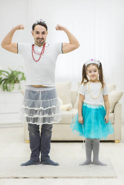 Father and his little daughter dancing against white background. - Foto, imagen