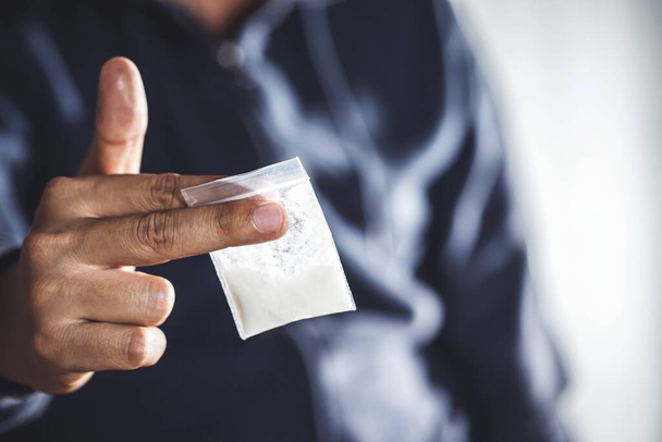 Hombre drogadicto sosteniendo heroína inyectable de jeringa de drogas a mano.Desastre social  - Foto, Imagen