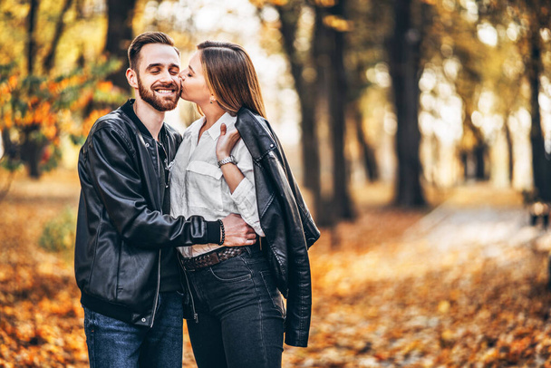 Portrait of a young loving couple. Man and woman hugging and smiling in the background of autumn park. - Φωτογραφία, εικόνα