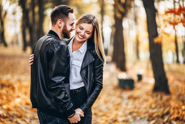 Portrait of a young loving couple. Man and woman hugging and smiling in the background of autumn park. - Foto, immagini