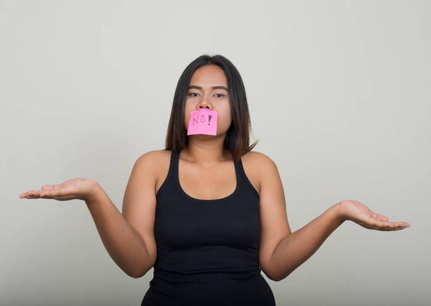 Studio shot of young overweight Asian woman against white background - Zdjęcie, obraz