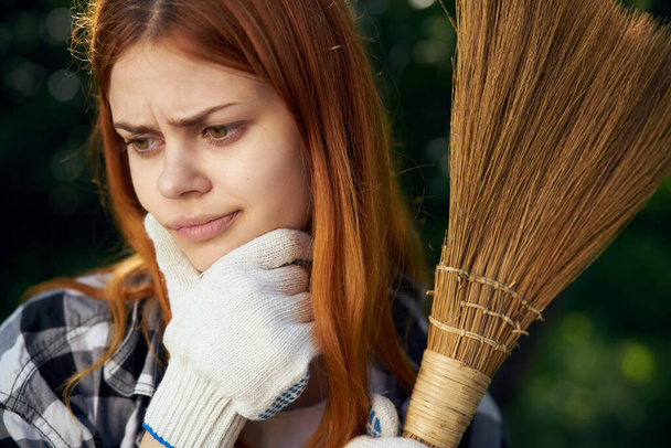 mujer con escoba en las manos guantes de construcción limpieza del jardín aire fresco - Foto, Imagen