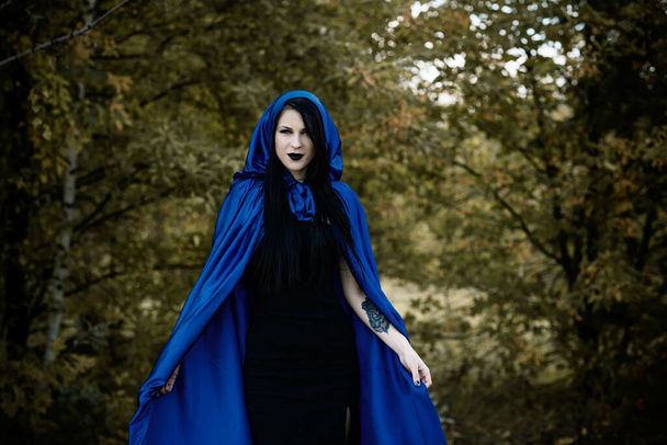 Halloween, čarodějnictví, moderní gotická dívka v modrém plášti slaví. Dobrý nápad na focení, cosplay - Fotografie, Obrázek