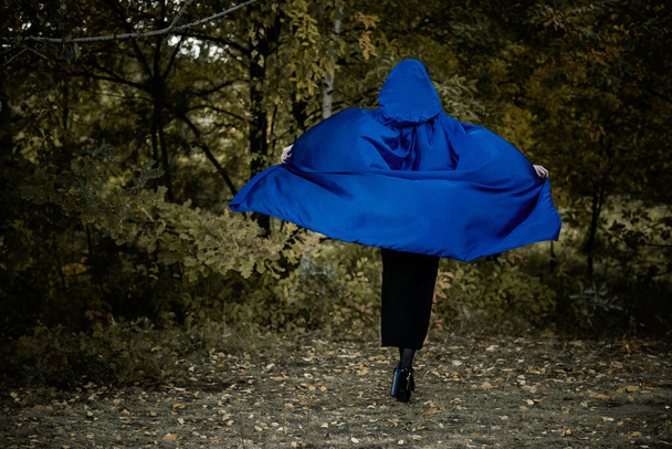 Halloween time, witchcraft, modern gothic girl in blue cloak celebrate. Good ideas for photoshoots, cosplay - Foto, imagen