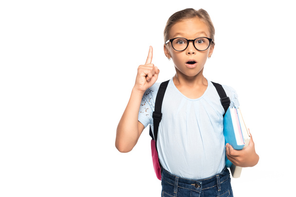 schoolgirl in glasses holding books while having idea isolated on white  - Foto, Bild