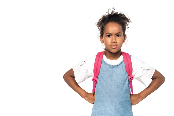 serious african american schoolkid looking at camera while standing with hands on hips isolated on white  - Фото, зображення