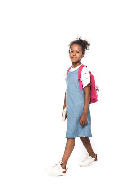 african american schoolkid looking at camera while walking isolated on white  - Φωτογραφία, εικόνα