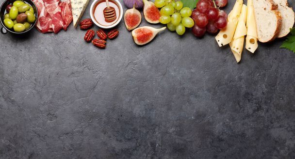 Antipasto plate with prosciutto, cheese, figs and grapes. Appetizer board. Top view flat lay with copy space - Фото, зображення