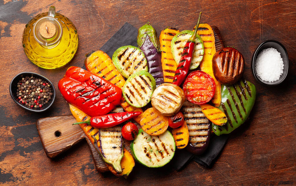 Grillezett zöldségek a vágódeszkán fűszerekkel és gyógynövényekkel. Top view lapos fektetés - Fotó, kép