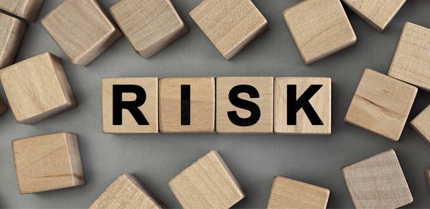 Слово Risk зроблено з дерев'яних будівельних блоків. Вид зверху
 - Фото, зображення