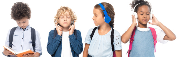 panoramisch concept van schoolmeisje luisteren muziek en kijken naar jongen lezen boek in de buurt van multiculturele schoolkinderen geïsoleerd op wit  - Foto, afbeelding