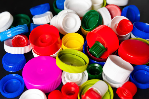 Close-up de tampas de garrafa de plástico reciclado. Tampas PET coloridas. Coleta de lixo separada. Reciclagem de plástico para próteses. Foco seletivo. Textura multicolorida. - Foto, Imagem