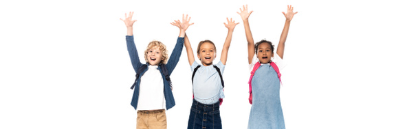 panoramic shot of excited multicultural schoolgirls and schoolboy with raised hands isolated on white  - Foto, Imagem