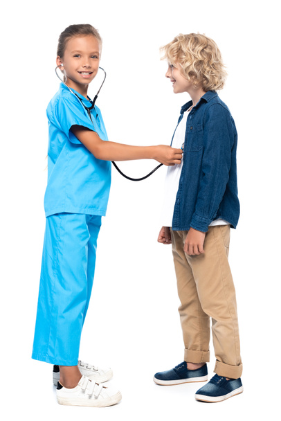 ребенок в костюме врача обследования блондинка и кудрявый мальчик изолированы на белом  - Фото, изображение
