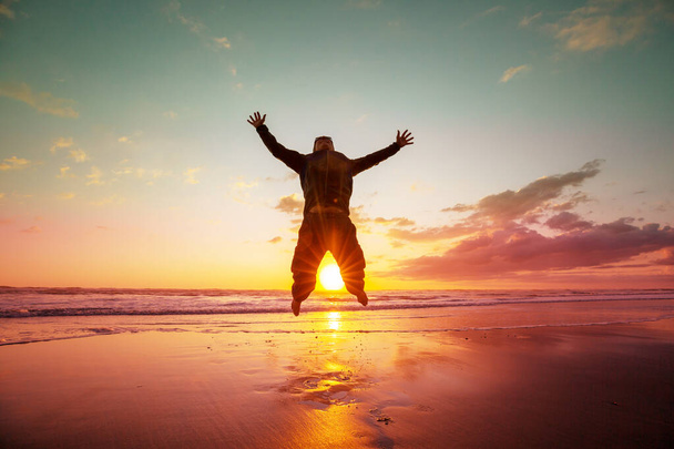 Πηδώντας άνθρωπος στην παραλία ηλιοβασίλεμα - Φωτογραφία, εικόνα