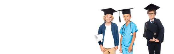 récolte panoramique d'enfants en casquettes de graduation vêtus de costumes de différentes professions tenant le plan et la mallette isolés sur blanc  - Photo, image