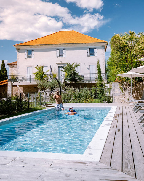 Francuski domek letniskowy z drewnianym tarasem i basenem w Ardeche Francja. Para relaksująca się przy basenie z drewnianym tarasem podczas luksusowych wakacji w domku letniskowym na południu Francji - Zdjęcie, obraz